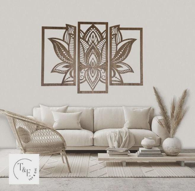 Decorative wall art of a 3 piece mandala lotus flower in a living room setting with a sofa and wicker chair.