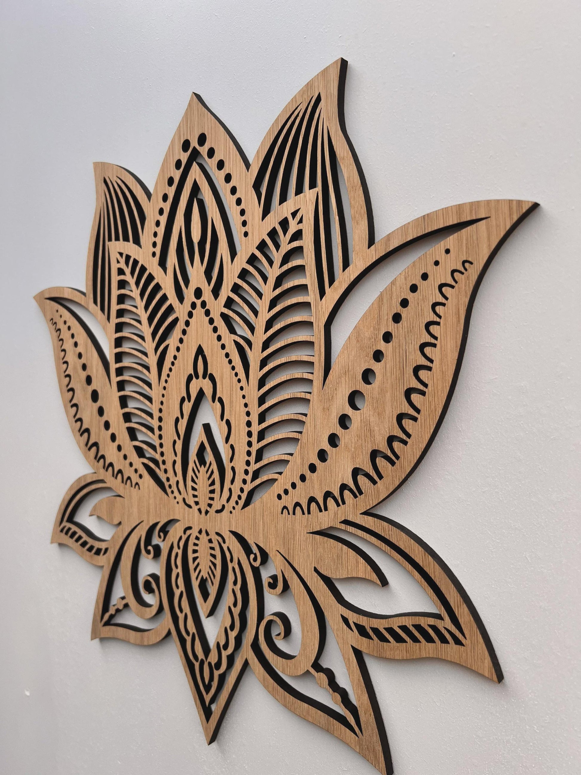 Wooden wall art with intricate laser-cut design on a plain background