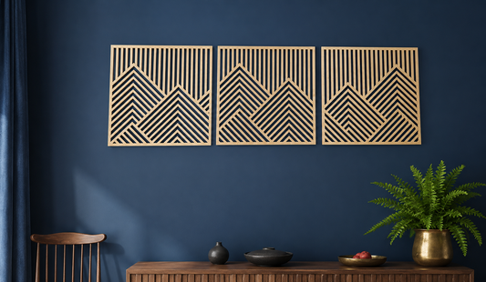 Three geometric mountains wall art piece on a blue wall with a wooden console table and plant.