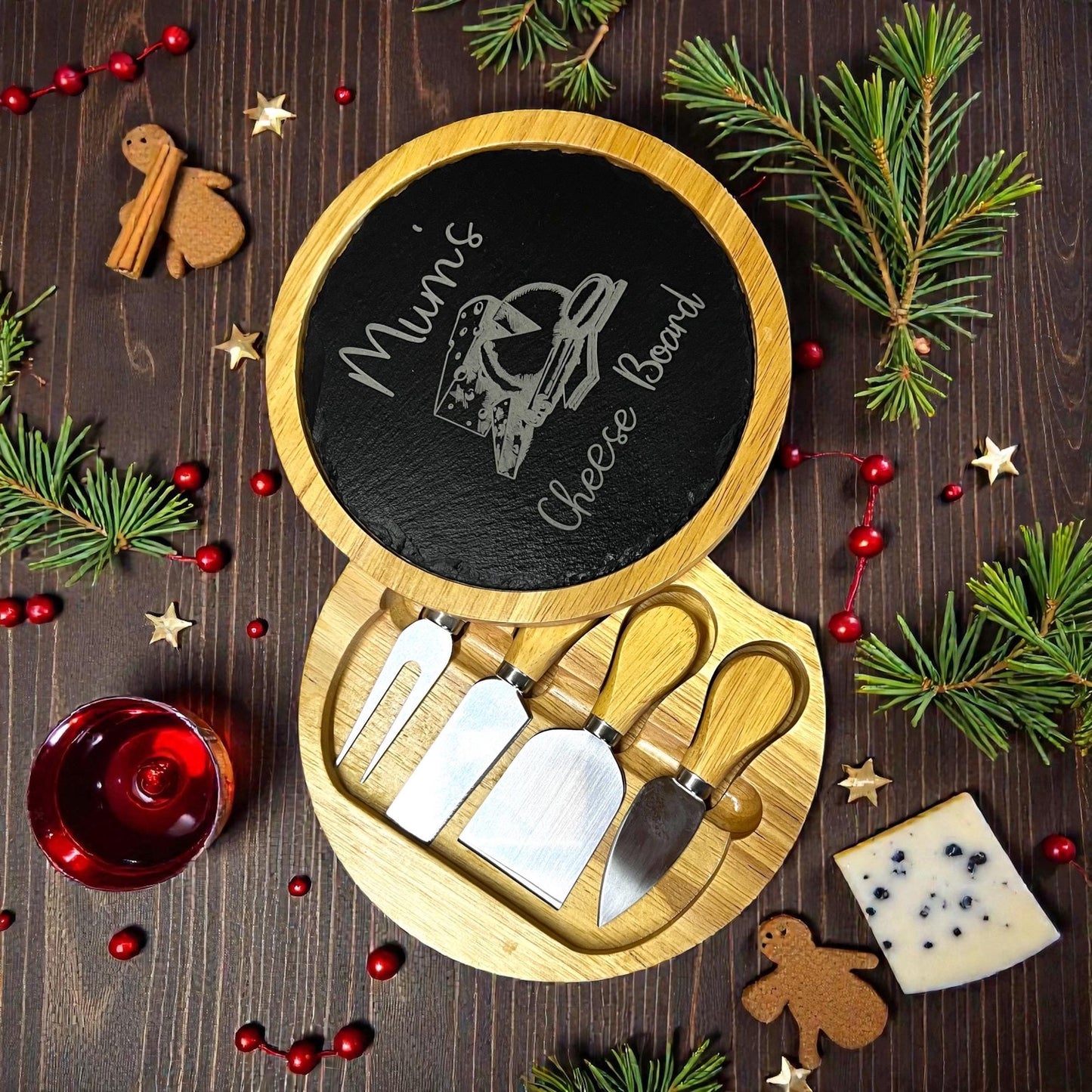 Cheese board set with tools on a wooden surface with Christmas decorations