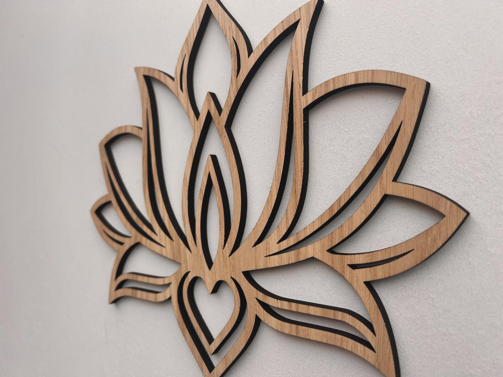 Wooden lotus flower wall art on a light gray background